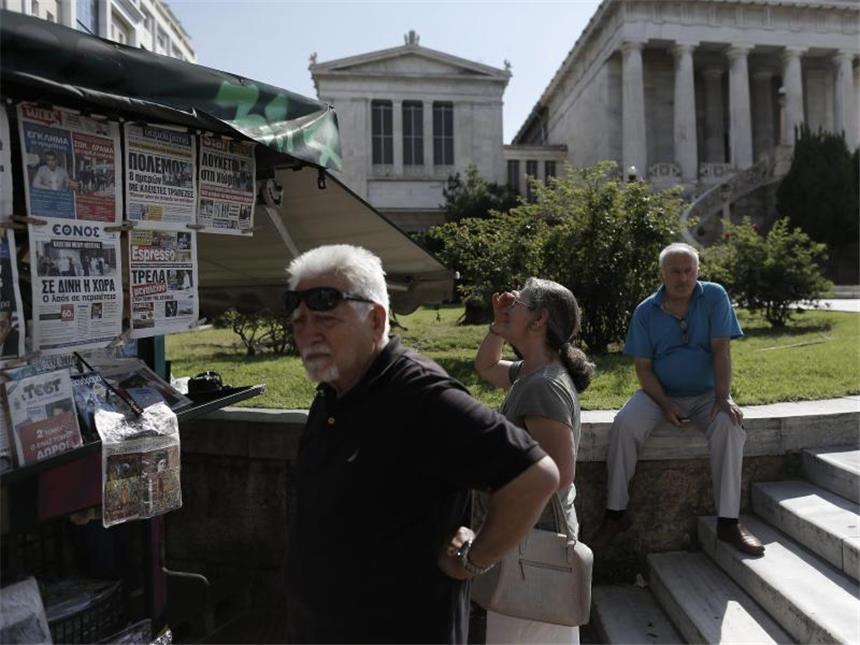 Dramatischer Poker im griechischen Schuldenstreit Wie geht es weiter? Menschen in Athen studieren die Schlagzeilen der Zeitungen an einem Kiosk. Foto: Yannis Kolesidis