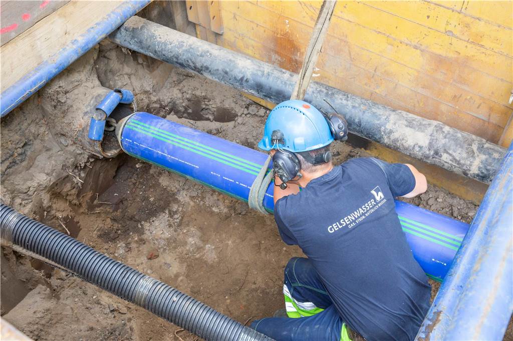 Ein Gelsenwasser-Arbeiter schiebt in Haltern ein neues Wasserrohr aus Kunststoff einfach in eine alte Leitung.