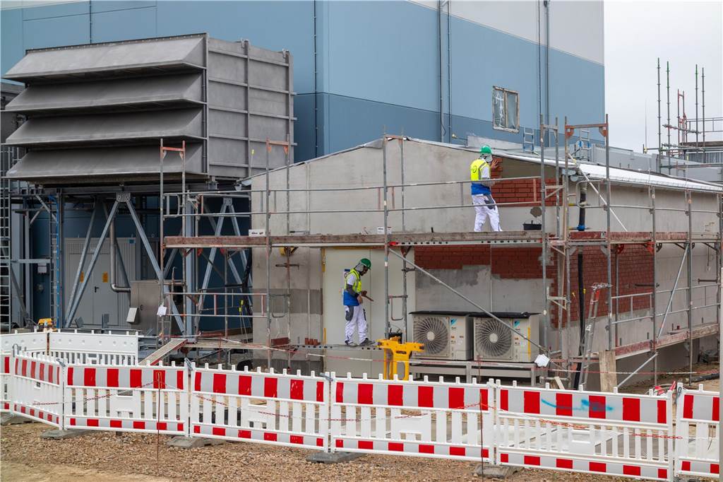 Was genau macht die neue Gas-Verdichterstation? Verantwortliche geben Einblick Ein Blick auf die Halle eines Gasverdichters und ein Nebengebäude.