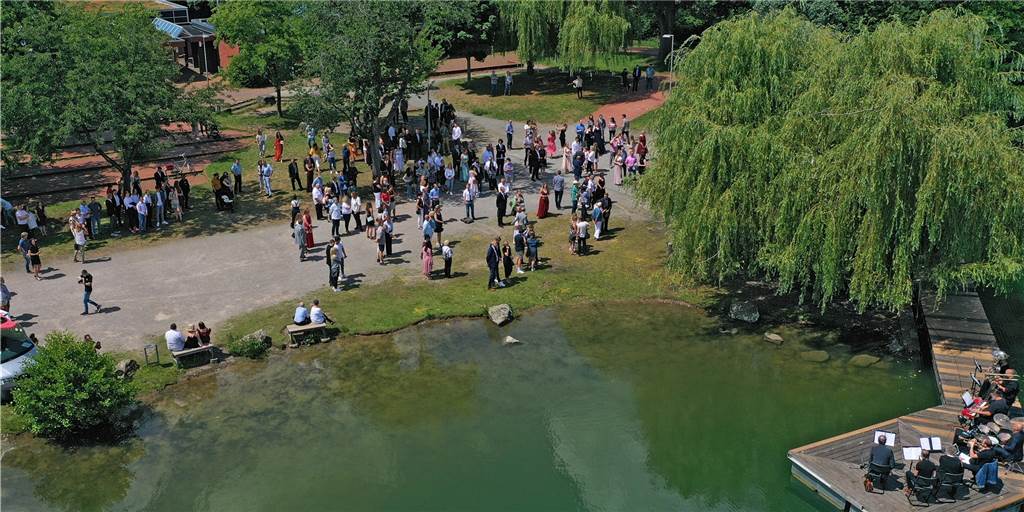 Abibälle in Dorsten: Schulen kehren langsam zur Normalität zurück Abiturientinnen und Abiturienten der Gesamtschule Wulfen stehen bei sonnigem Wetter draußen am Barkenberger See.