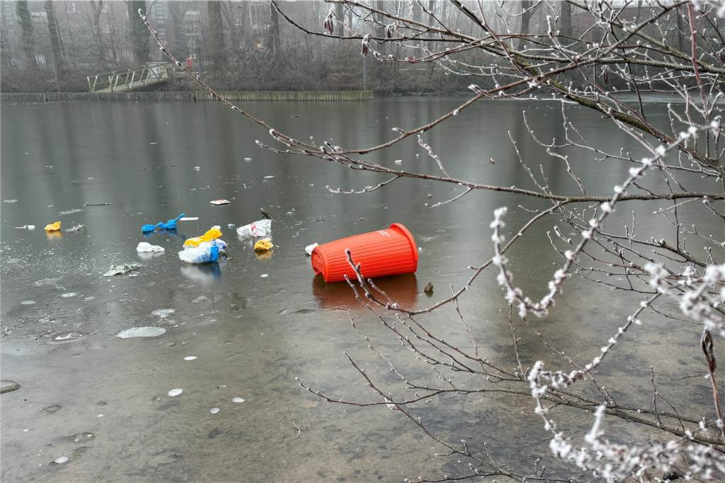 Minusgrade lassen Gewässer zufrieren: Dünne Eisfläche birgt Gefahren Ein abgetretener Mülleimer sowie dessen Inhalt liegen auf dem Eis des zugefrorenen Barkenberger Sees in Dorsten.