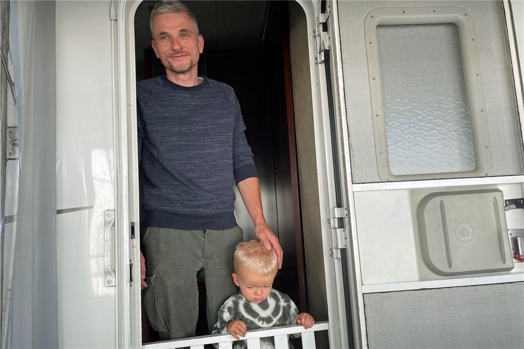  Timo Röber mit dem kleinen Mason an der Eingangstür des Wohnwagens.
