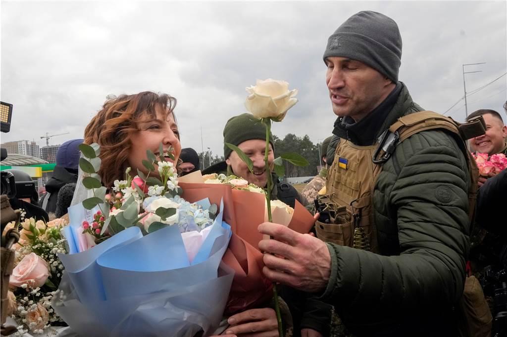 Putins Krieg in der Ukraine: Fünf Geschichten, die Mut machen Wladimir Klitschko (r), ehemaliger ukrainischer Box-Profi, gratuliert den frisch verheirateten Mitgliedern der ukrainischen Territorialen Verteidigungskräfte Lesia Iwashchenko (l) und Walerii Fylymonow nach einer Hochzeitszeremonie an einem Kontrollpunkt.