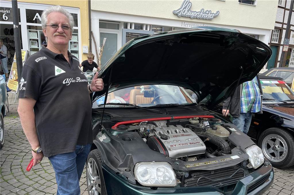 Oldtimertreffen in Werne: Historische Autos sorgen für staunende Augen Ein Mann steht neben einem Auto mit geöffneter Motorhaube.