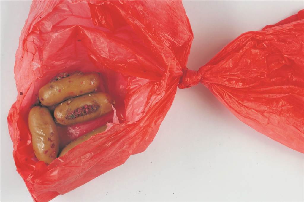 Giftköder-Verdacht: Familie Meyer trauert um Hündin Leia – qualvoller Tod nach Spaziergang Würstchenstücke, die mit Gift präpariert wurden, liegen auf einem roten Hundekotbeutel.