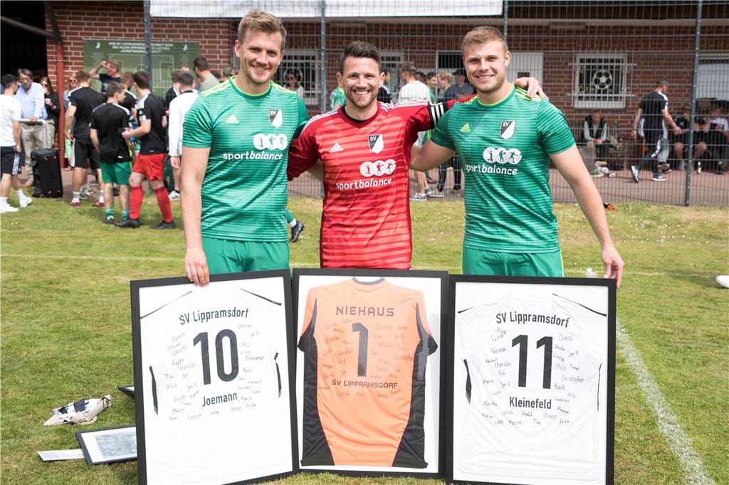 Robin Joemann, Marvin Niehaus und Henrik Kleinefeld mit ihren Abschiedsgeschenken beim SV Lippramsdorf