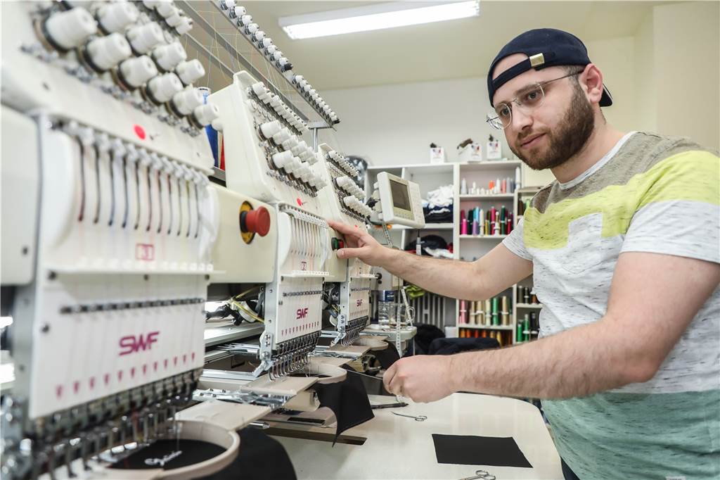 „Kenne keinen, der sowas anbietet“: Kreative Masken-Idee aus Körne Yahia Alyasen arbeit an der Stickerei-Maschine, mit der die Masken bestickt werden.