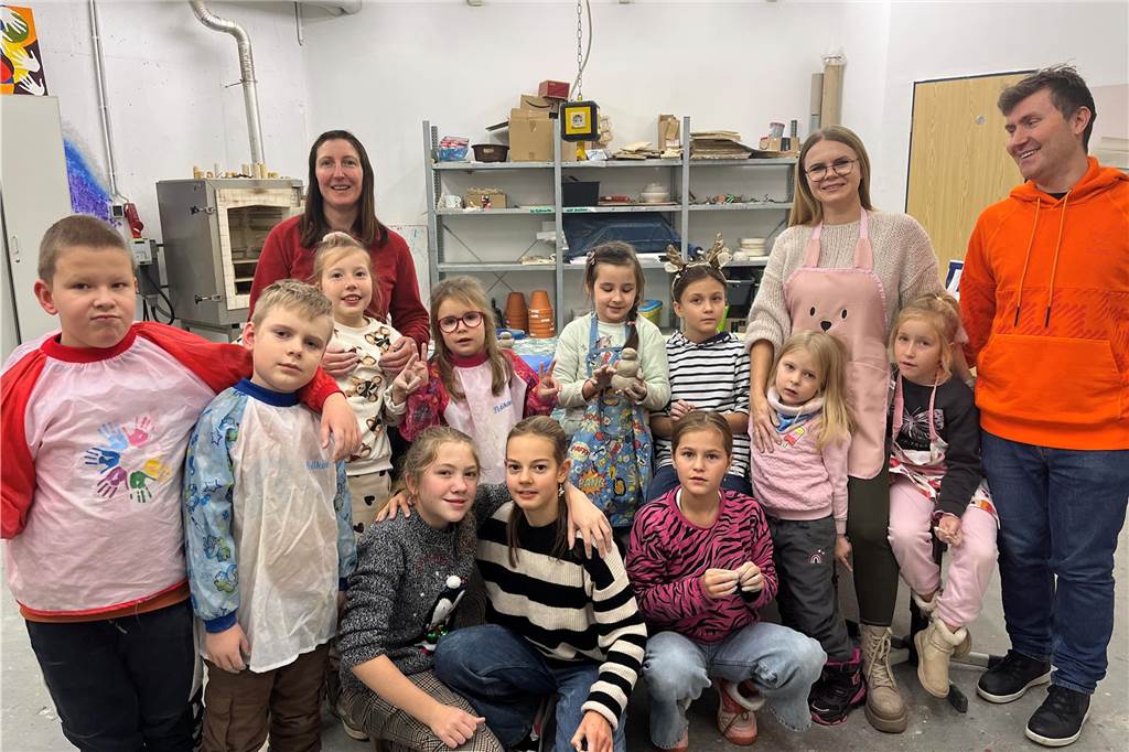 Töpferkurs für Kinder: Ukrainerin fördert die kreative Bildung Drei Erwachsene und eine Reihe Kinder haben sich zum Gruppenfoto aufgestellt.