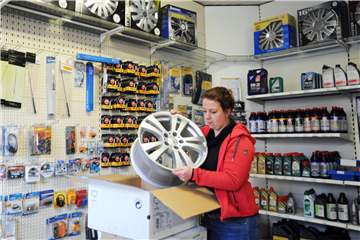 Yvonne Jasper packt eine Felge aus – als Werkstattleiterin ist sie auch für den Shop zuständig und kompetente Ansprechpartnerin für alle, die Zubehör oder Pflegemittel fürs Auto brauchen.