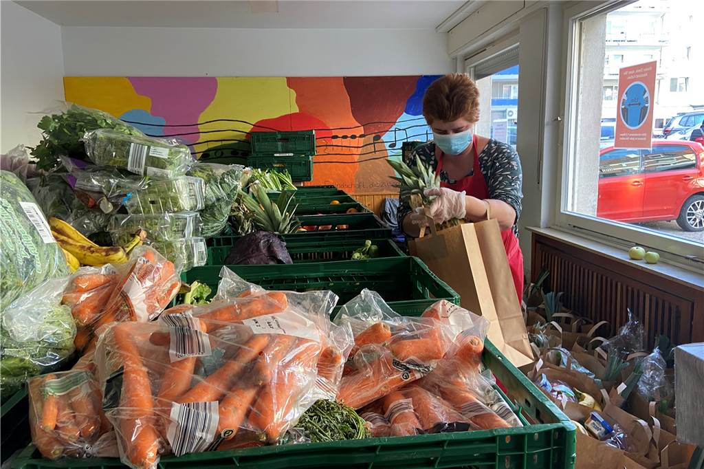 Eine Caritas-Mitarbeiterin packt Lebensmitteltüten für Bedürftige