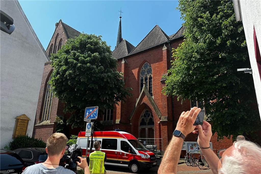Höhenretter musste für einen Wanderfalken auf den kleinen Kirchturm Schaulustige mit Handys an der Sixtuskirche
