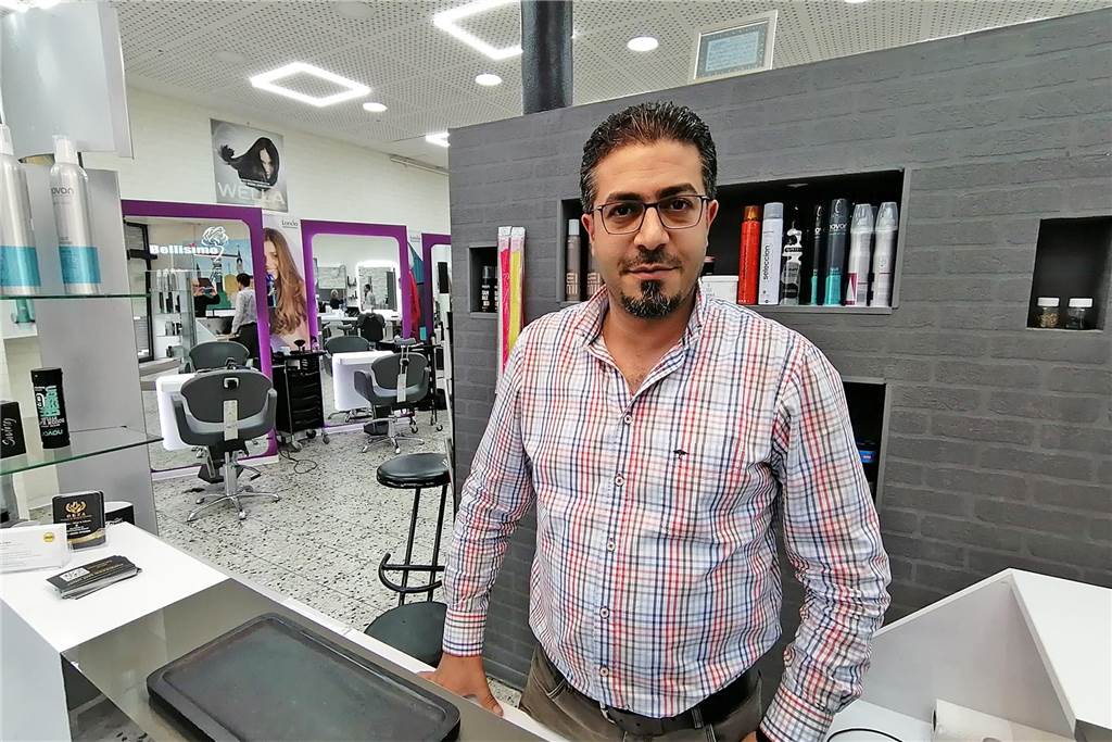 Friseur Zakaria Al-Nasser hinter der Kassentheke in seinem Salon in der Castrop-Rauxeler Altstadt.