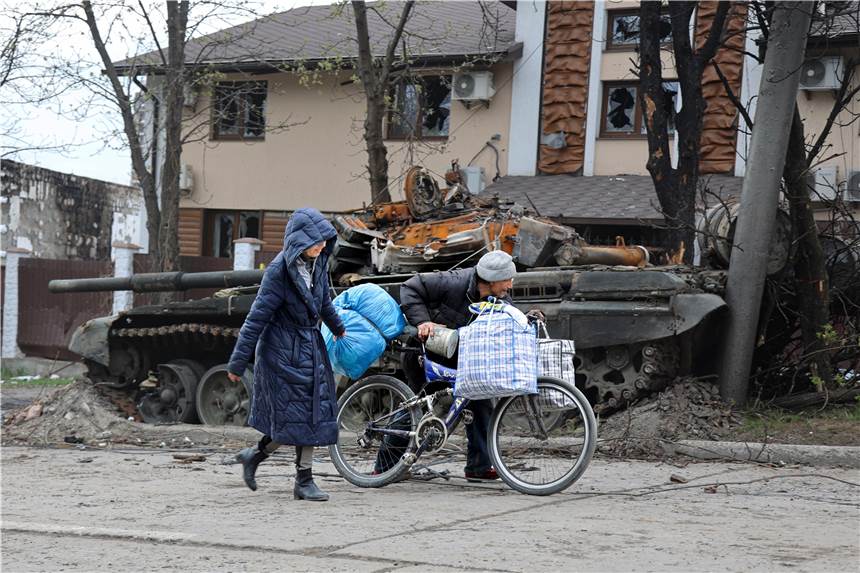 Hunderttausende Zivilisten könnten zwischen die Fronten geraten Zivilisten gehen an einem Panzer vorbei, der bei schweren Kämpfen in einem von den von Russland unterstützten Separatisten kontrollierten Gebiet in Mariupol zerstört wurde.