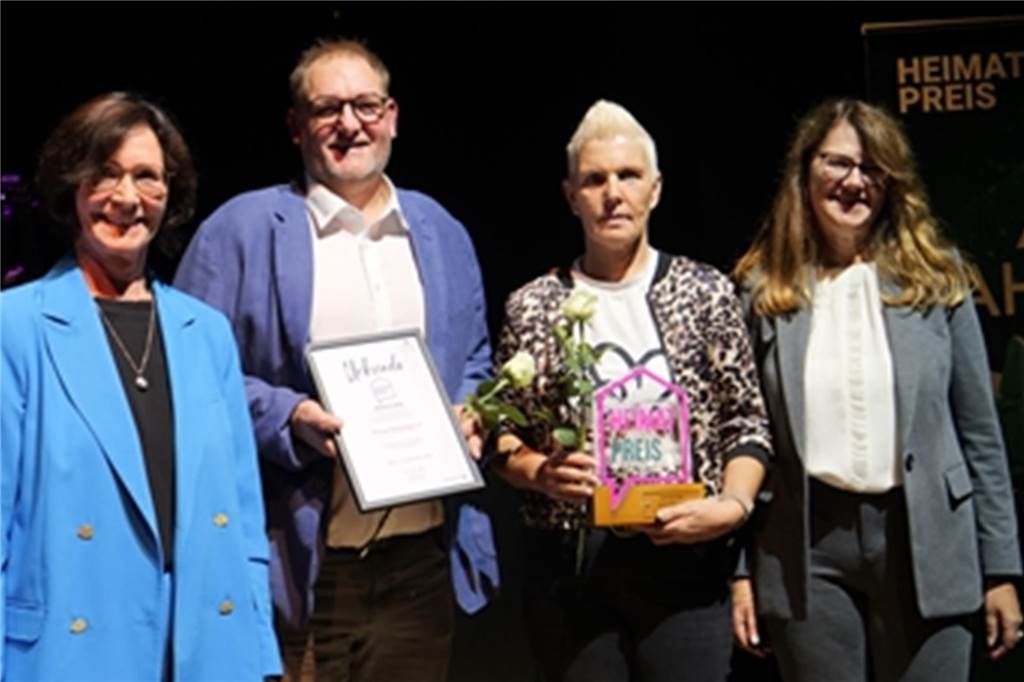 Bullemänner sorgen bei Ahauser Ehrenamtsgala für gute Laune Renate Schulte, Vorsitzende des Ausschusses für Kultur, Tourismus und Ehrenamt, Preisträger Maidy Dogs und Bürgermeisterin Karola Voß