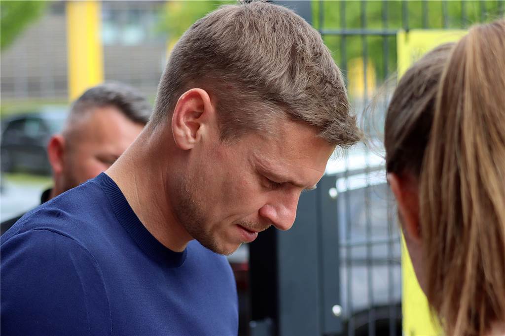 Lukasz Piszczek schreibt Autogramme. 