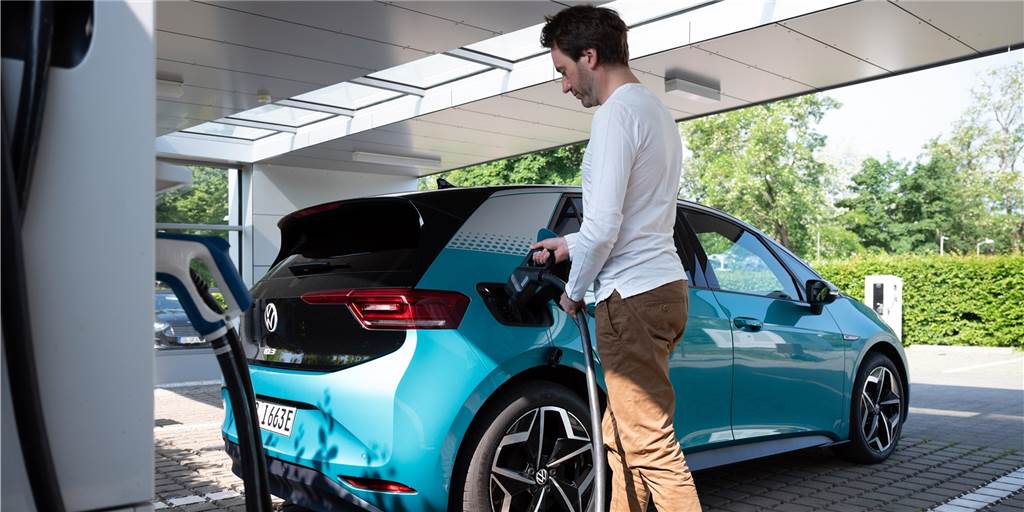 Acht Mythen über E-Autos - und was Experten dazu sagen Ein Mann lädt sein E-Auto an einer Ladestation auf.