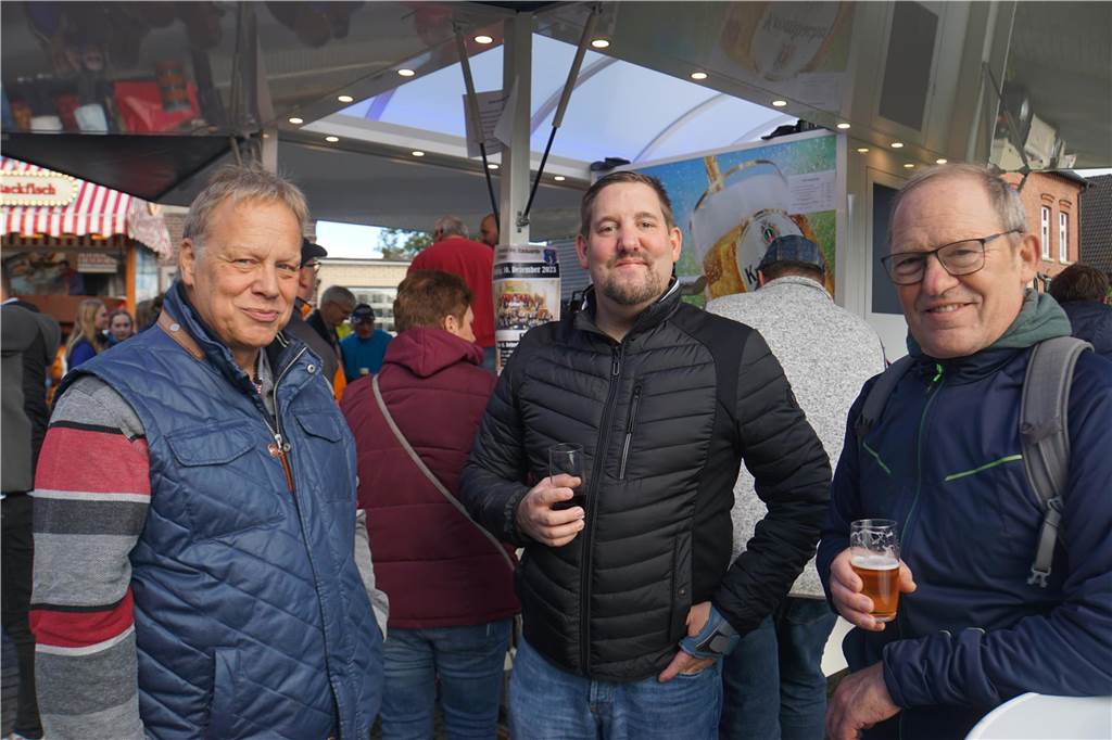 Männer stehen am Getränkewagen und trinken Bier.