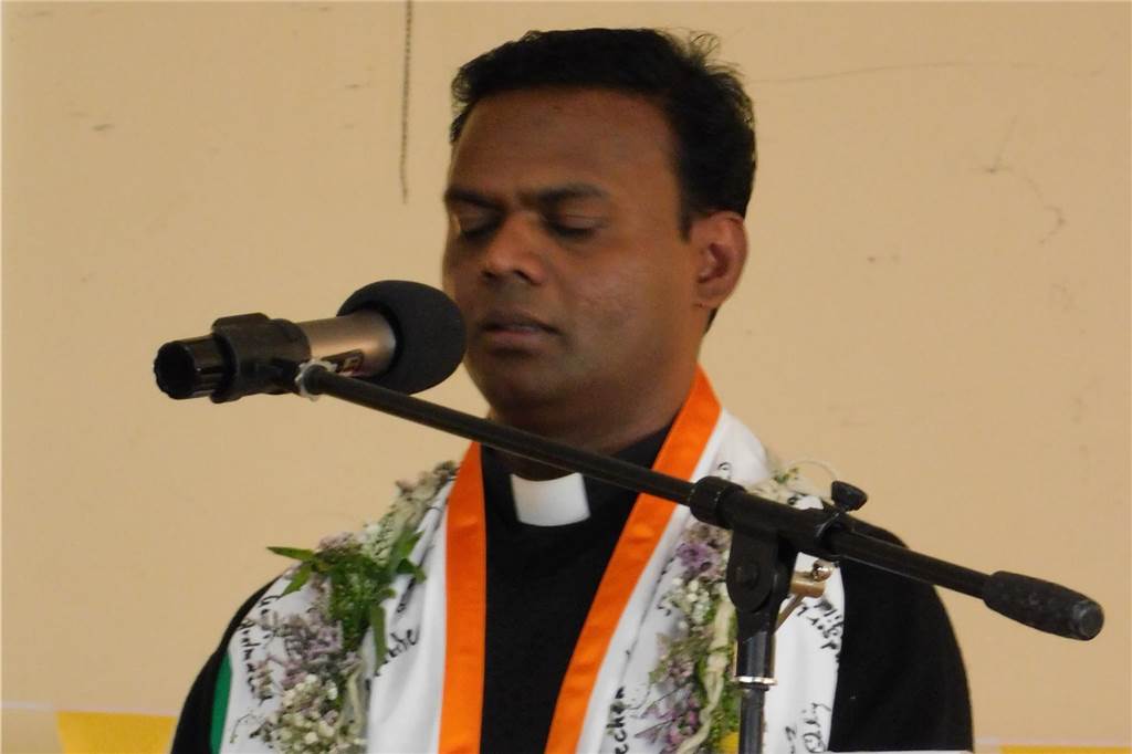 Pater Raju am Mikrofon
