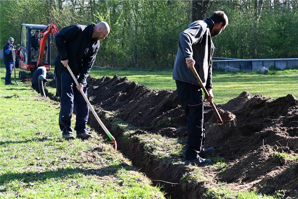 Eigener Stromanschluss für Schützenfestplatz in Wulfen: Alle packen mit an Männer heben einen Graben aus.