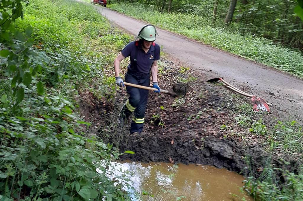 Umgestürzter Anhänger mit Güllefass ruft Feuerwehr Werne auf den Plan Ein Feuerwehrmann mit einer Schaufel.