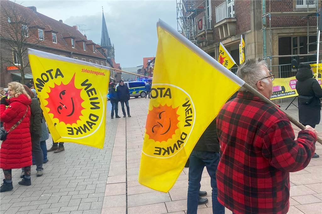 400 Demonstranten fordern den Stopp der Castor-Transporte einige Menschen halten Fahnen in der Ahauser Innenstadt