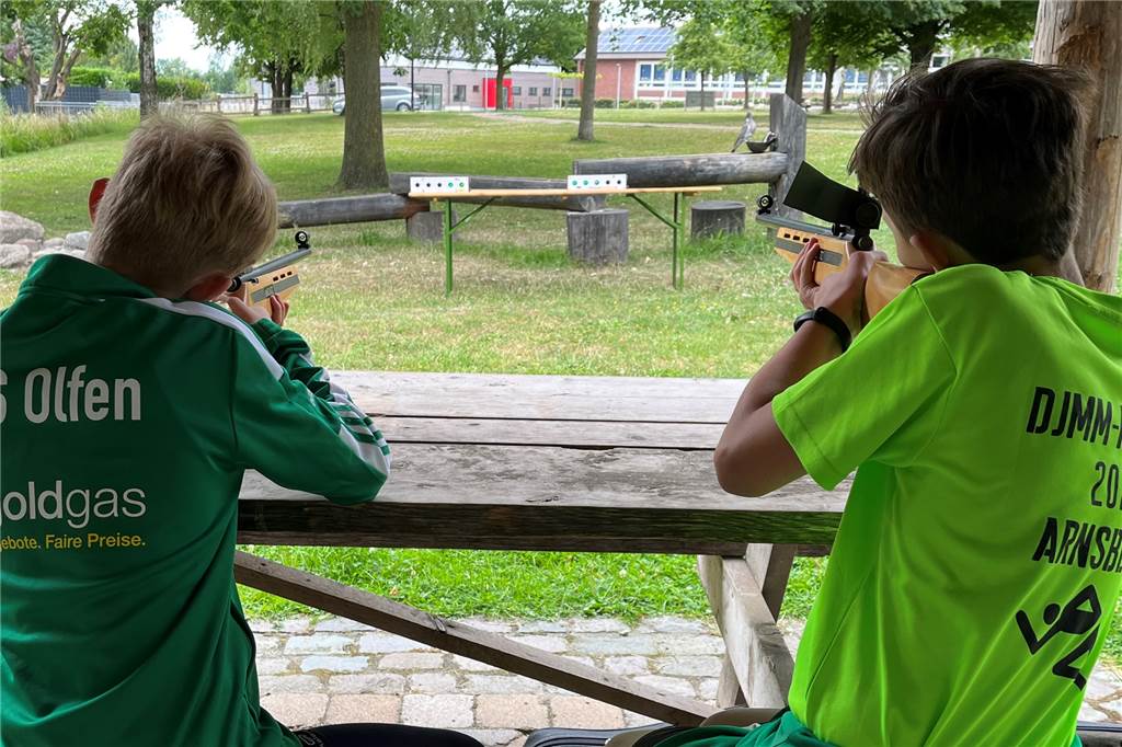 Sommerbiathlon mit Lasergewehren bei Sport im Park gestartet Zwei Athleten des Sommerbiathlons am Schießstand. Mittels Laser wird bei einem Treffer ein grünes Licht ausgelöst.