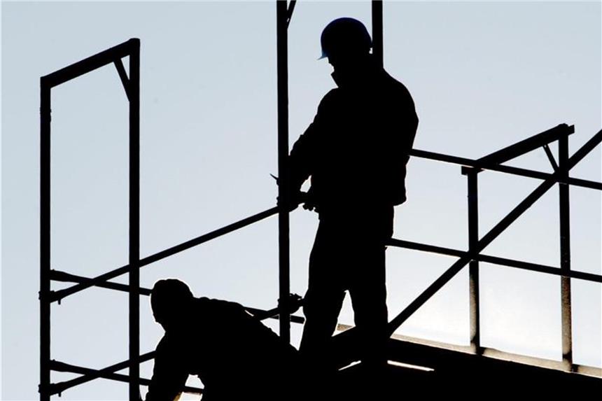 Großrazzia gegen Schwarzarbeit auf dem Bau: Festnahmen Zwei Bauarbeiter arbeiten im Gegenlicht auf einem Gerüst. Foto: Boris Roessler/Archiv