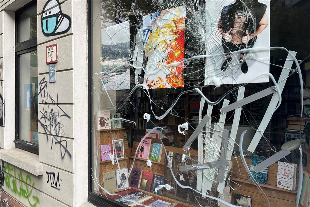 Drohanrufe und zerstörte Scheiben: Angriff auf alternativen Buchladen Zwei große Fenster des Buchladens wurden bei dem Angriff beschädigt. Hinter diesen sind Fotografien einer Dortmunder Künstlergruppe ausgestellt.