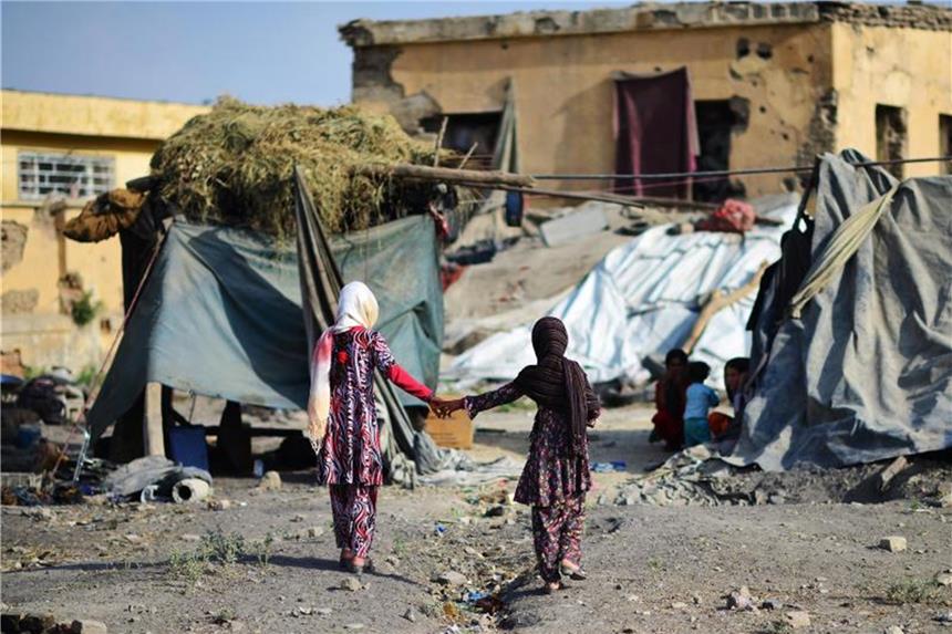 Zwei Mädchen laufen durch ein Flüchtlingslager für Binnenvertriebene in Kabul. Foto: Hannibal/Archiv