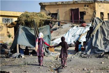 Zwei Mädchen laufen durch ein Flüchtlingslager für Binnenvertriebene in Kabul. Foto: Hannibal/Archiv