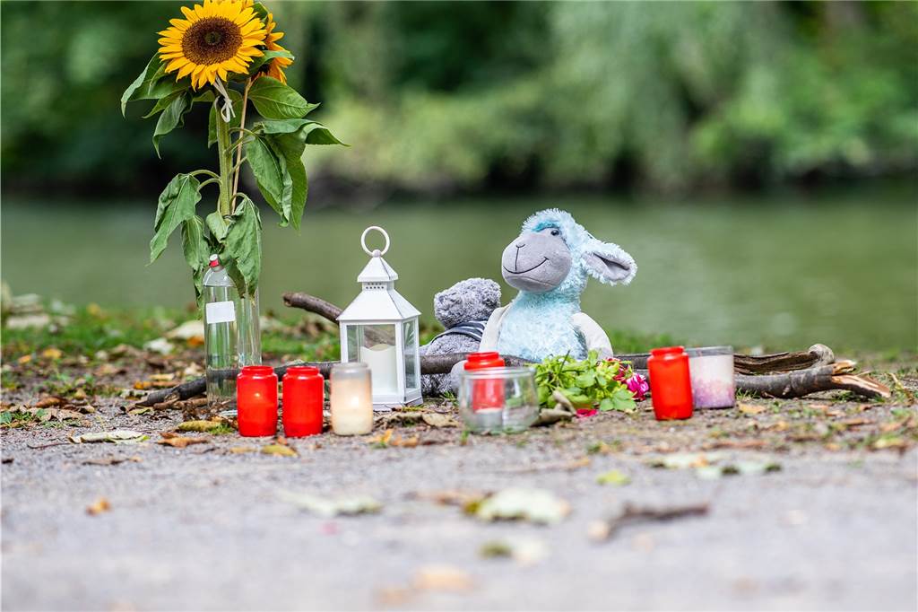 Frauenleiche in Hamm: Polizei lässt 27-Jährigen frei – doch er wird weiter beschuldigt Zwei Stofftiere, Kerzen und Sonnenblumen stehen an dem kleinen See am Oberlandesgericht, wo am Sonntag eine Frauenleiche gefunden wurde.