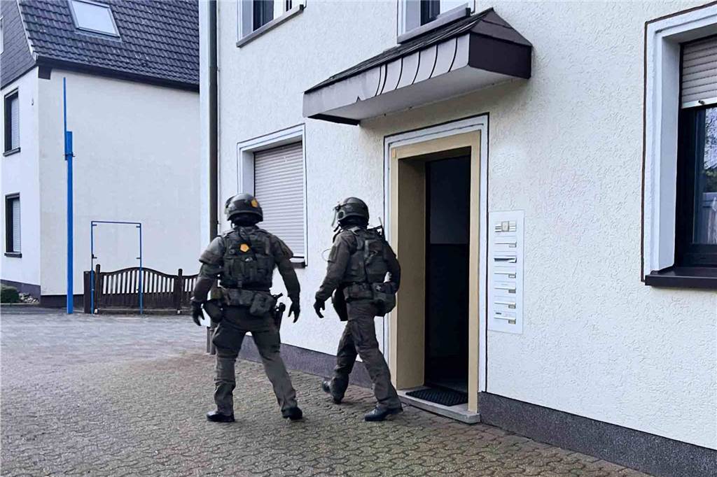 Vermummte SEK-Kräfte verlassen ein Haus in Datteln.