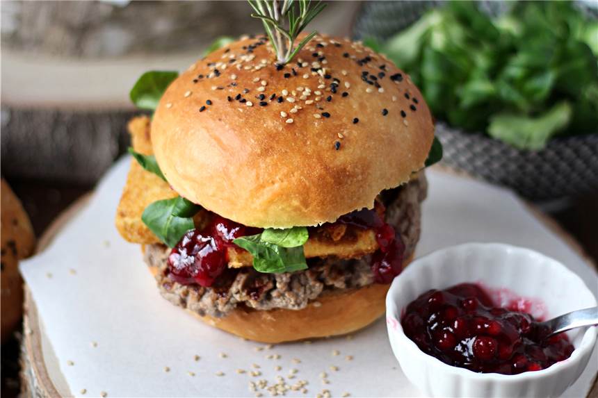Burger mit gebackenem Camembert und Preiselbeersoße Zwischen die selbst gebackenen Brötchen-Hälften werden Hackfleisch-Patties, panierte Camembert-Streifen, Preiselbeeren und Feldsalat geschichtet.